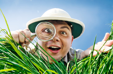 Young Man Looking through a Magnifying Glass