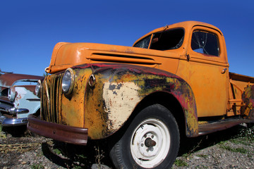 Fototapeta premium Old yellow pick up against blue sky