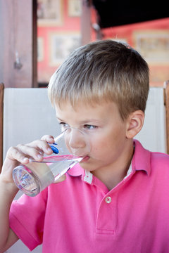 Boy drinks water from a glass