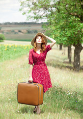 Redhead girl with suitcase at outdoor.