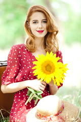 Redhead girl with sunflower at outdoor.