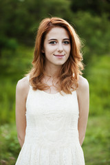 Naklejka premium Redhead girl at green grass at village outdoor.