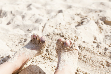 child's legs in the sand