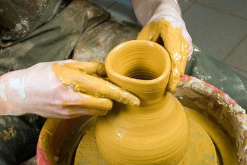 hands of a potter, creating an earthen jar on the circle