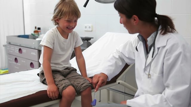 Doctor testing reaction of a child leg