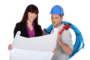 businesswoman and craftsman looking at a blueprint