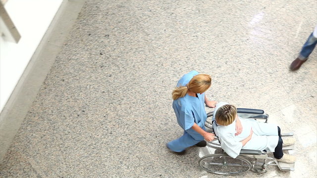 High angle view of a nurse wheeling a patient in a wheelchair