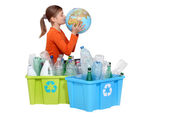 Girl recycling bottles and kissing a globe
