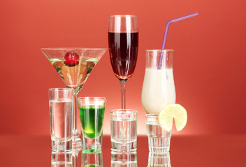 a variety of alcoholic drinks on red background