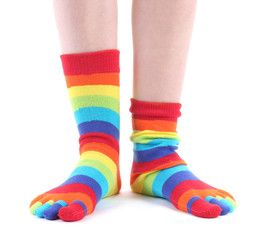 female legs in colorful striped socks isolated on white