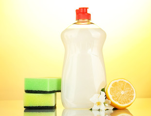 Dishwashing liquid with sponges and lemon with flowers