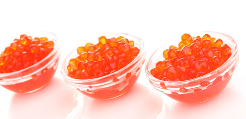 Red caviar in glass bowls isolated on white