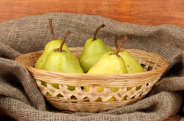 Ripe pears in sack on wooden background close-up