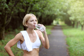 Woman is drinking water after sport