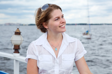 Fototapeta na wymiar Girl in a white shirt on board the yacht looking away