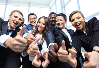 Happy multi-ethnic business team with thumbs up in