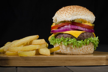 Gourmet Cheeseburger & Chips on a black background