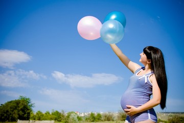 beautiful pregnant woman on a meadow with blue sky