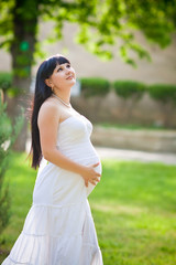 Beautiful pregnant woman relaxing in the park