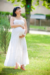 Beautiful pregnant woman relaxing in the park