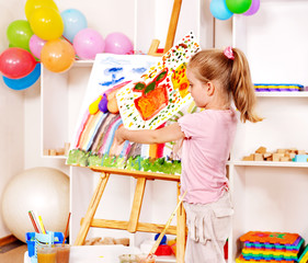 Child painting at easel.