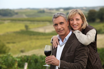 Couple with wine glass in front of vineyard