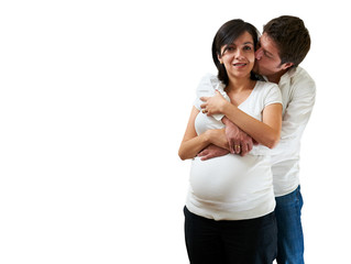 Young pregnant couple hugging on white background