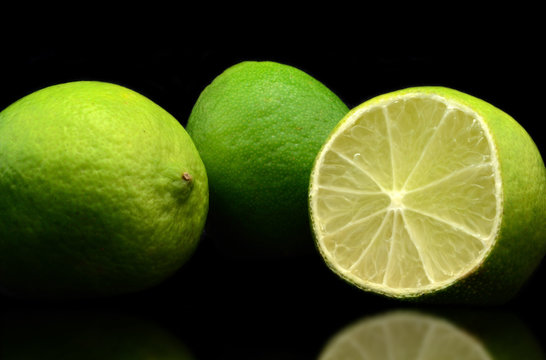 Three fresh limes isolated over black background