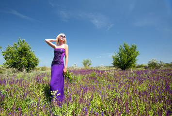 Pretty blond woman in field with purple flowers