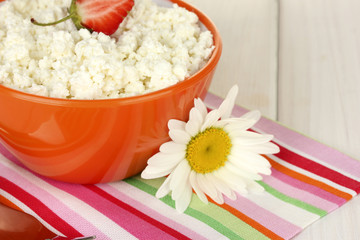 cottage cheese with strawberry in orange bowl, fork and flower