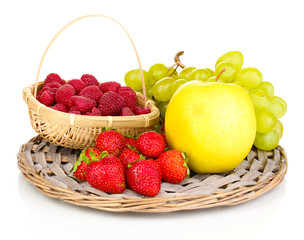 ripe sweet fruits and berries on wicker mat isolated on white