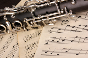 Musical notes and clarinet on wooden table