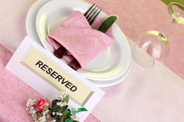 Table setting with reserved card in restaurant