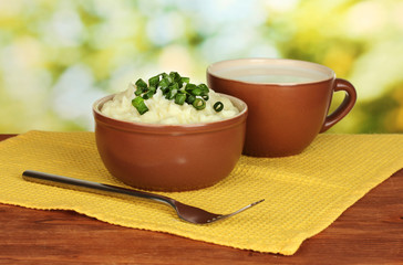 Mashed potato in the bowl and cup with milk