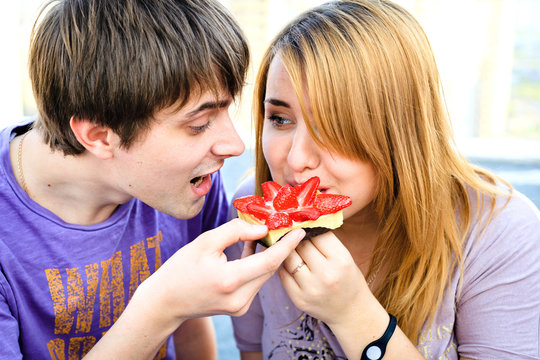 couple eating a dessert with strawberries