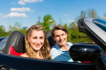 Young couple with cabriolet in summer on day trip