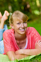 lachende Frau liegt auf Wiese