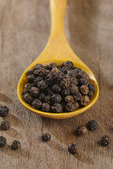 black pepper on wooden spoon