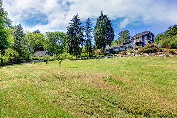 Obraz premium Large property with blue house and trees.
