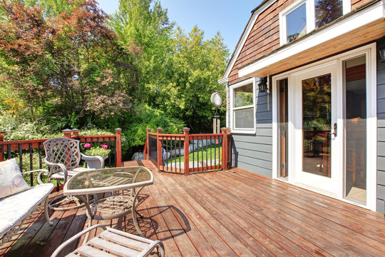 House Exterior With Large Open Deck With Outdoor Furniture.