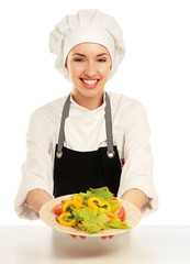 Pretty cook chief holding salad, isolated on white background