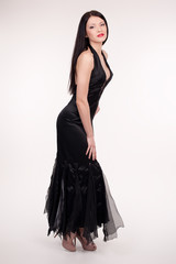 Fototapeta premium Beautiful young woman wearing a sexy black evening dress
