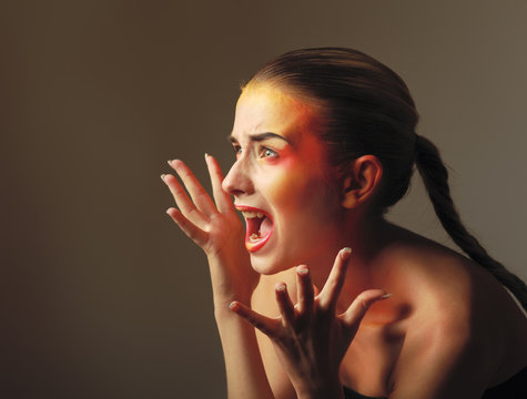 Scared young woman gesturing on grey  background