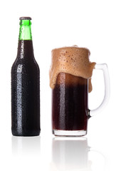 Frosty glass of dark beer with bottle isolated