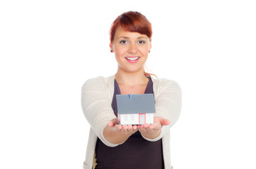 junge frau zeigt miniatur-eigenheim