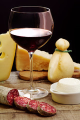 selection of dairy product, salami and red wine