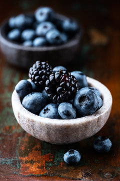 Blueberries and blackberries in small dishes