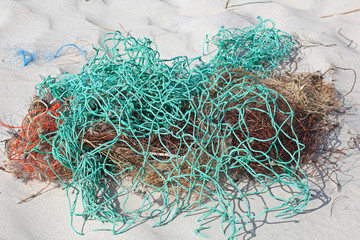 Plastikmüll und Reste von Netzen am Strand