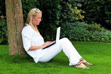 Frau mit Laptop Computer im Garten