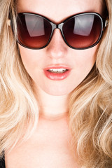 studio closeup portrait of a young beautiful woman in sunglasses